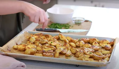 Достаньте запечённую картошку из духовки, посыпьте петрушкой и сразу подавайте к столу.

