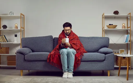 Грипп и простуда профилактика: фото мужчины на диване с кружкой и в пледе