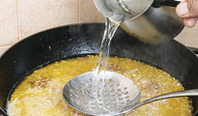 Промойте рис и выложите поверх лука, долейте горячей воды, если нужно. Вода должна быть выше риса не более чем на 3 см.