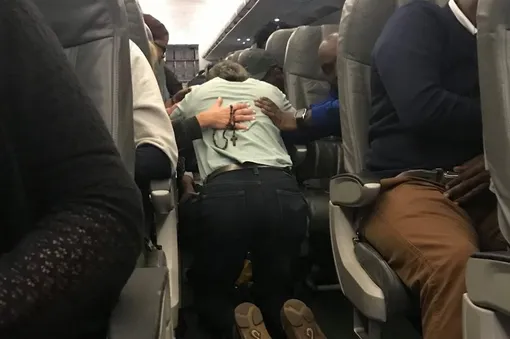 Пассажиры придерживают врачей руками, чтобы их не трясло во время посадки