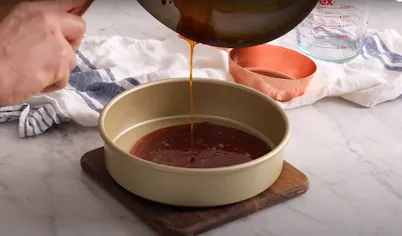 Осторожно перелейте горячий сироп в форму для выпечки. Поворачивайте форму, чтобы сироп равномерно покрыл дно и бока.
