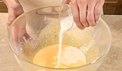 Влейте тонкой струйкой молоко в желтки, постоянно помешивая.