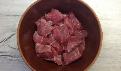 На дно посуды налейте 2 ст.л. растительного масла, выложите мясо.