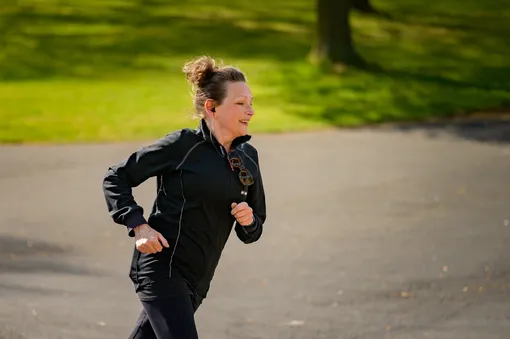 Женщина бегает в парке, мотивация к спорту
