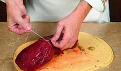 Рулет обвяжите кулинарным шпагатом и обжарьте на сковороде с растительным маслом со всех сторон.