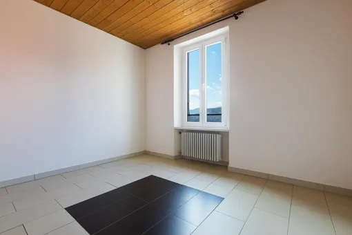 Пустая комната с деревянным потолком и белыми стенами