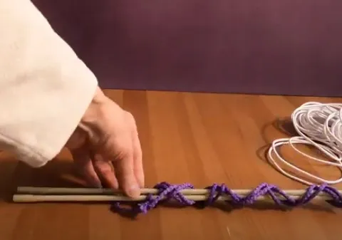 Готовый шнур из двух деревянных опор и синтетической сиреневой верёвки