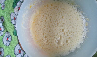 Растворить в молоке 1 чайную ложку сахара. Развести в молоке дрожжи. Оставшийся сахар растереть с желтками. Добавить дрожжевую смесь и перемешать.