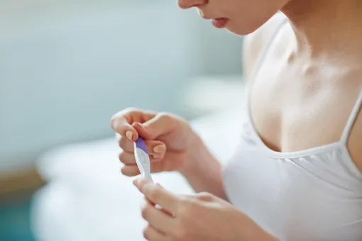 В руках девушки тест на беременность