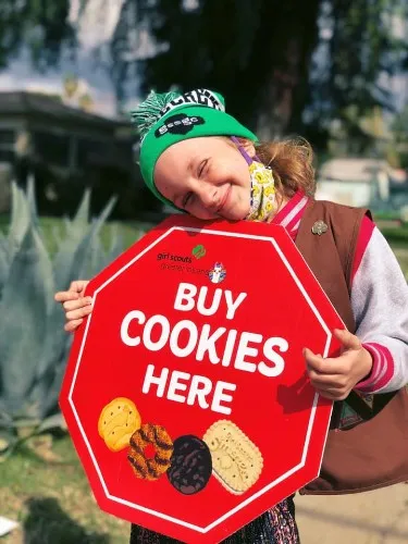 девочка скаут продает печенье