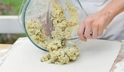 Репчатый лук очистите и мелко порубите, лук-порей вымойте, нашинкуйте. Разогрейте в сковороде 1 ст. л. рафинированного масла и обжарьте репчатый лук до золотистого цвета, добавьте порей и готовьте, помешивая, еще 2–3 минуты. Три яйца отварите, очистите и мелко порубите. Выложите картофельную начинку на тесто и распределите на 2/3 поверхности (не занимая дальнюю от вас часть теста).