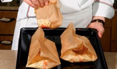 На противень выложите бумажные конверты и запекайте в разогретой до 200°С духовке 25 минут. Подавайте блюдо горячим.