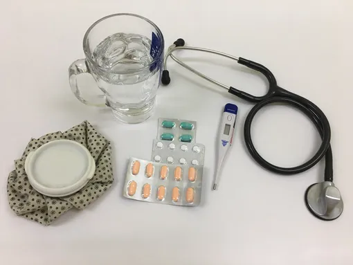 Предметы, чтобы измерять высокую температуру и лечить: градусник, стетоскоп, таблетки, вода