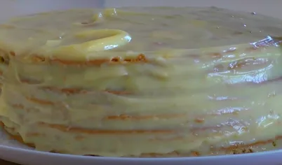 Смажьте остывшие медовые коржи заварным кремом. Промажьте бока и верх торта.