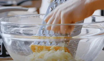 Для приготовления драников очистите, тщательно вымойте и натрите на мелкой терке сырой картофель.