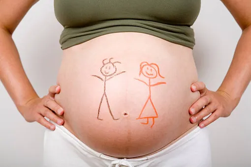 обнаженный беременный живот с двумя схематично нарисованными фигурками — мальчик и девочка