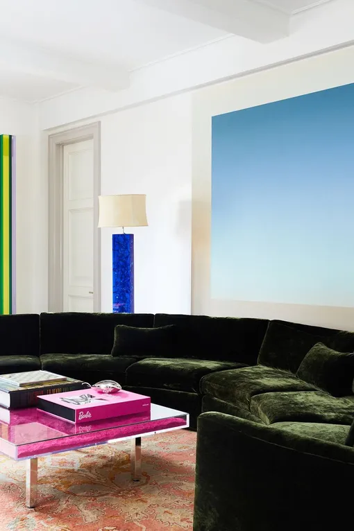 Современная гостиная с розовым журнальным столиком, зелёным диваном и голубым панно