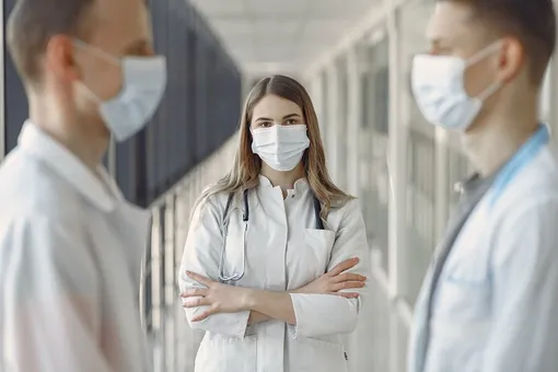 трок врачей в маске стоят полукругом