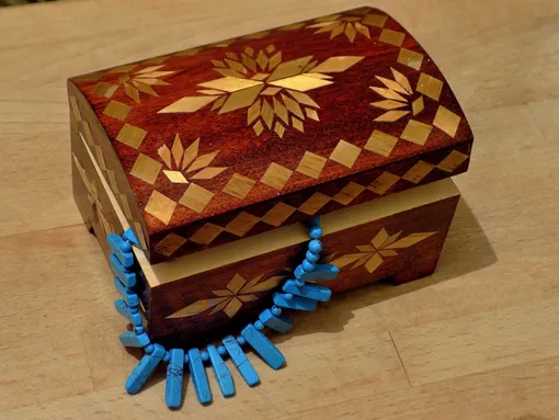 деревянная шкатулка с выглядывающим украшением
