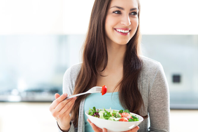 Девушка ест салат из меню диеты зигзаг