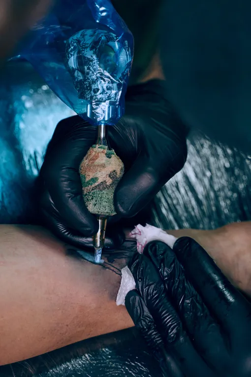 парень делает татуировку в подарок жене
