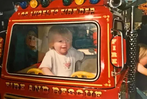 Двухлетняя Зоуи позирует, сидя в кабине пожарной машины