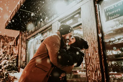 влюбленная пара обнимается под снегом