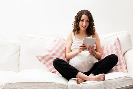 Беременная женщина читает книгу