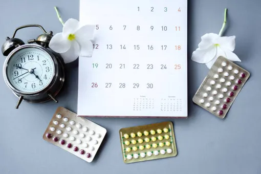 календарь, таблетки, будильник, два белых цветка