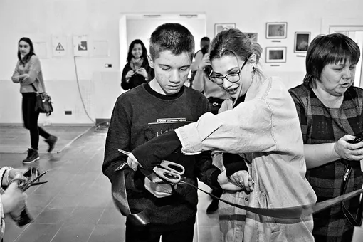 Анна и подопечный фонда Вадим открывают выставку картин и фотографий от людей с аутизмом