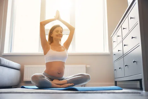 Беременная женщина делает зарядку