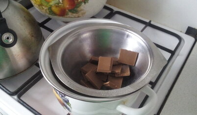 Сначала приготовьте крем. Для этого половину шоколада растопите на водяной бане.