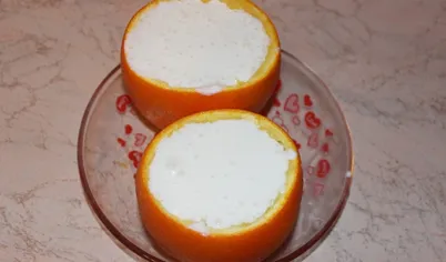 В апельсиновые чашечки выложить кубики ананасов и заполнить полученной творожной смесью. Убрать в холодильник на пару часов для застывания.