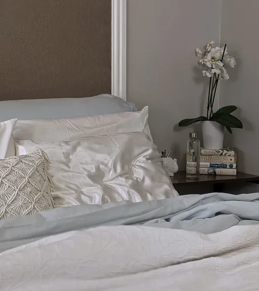 Белые шелковые подушки на кровати