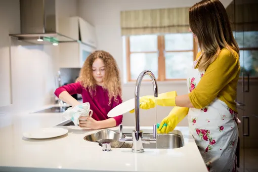 Мать и дочь моют посуду на кухне