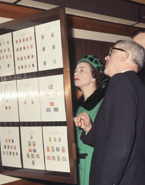 Королева Елизавета II рассматривает марки