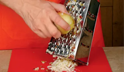 Сочные яблоки натрите на крупной терке, выложите в посуду и условно разделите на 2 части.