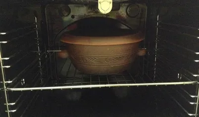 Закройте крышку посуды и поставьте ее в предварительно разогретую до 180 градусов, духовку.