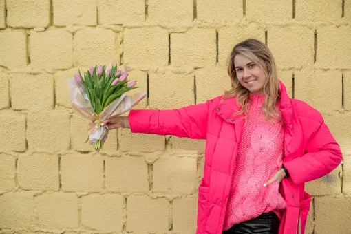 девушка держит букет тюльпанов на вытянутой руке Поздравления с 8 марта подруге