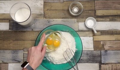 Разбейте яйца в миску с мукой, смешайте венчиком, влейте молоко и замесите блинное тесто. Добавляйте молока столько, сколько понадобится, чтобы тесто по консистенции напоминало жидкую сметану.