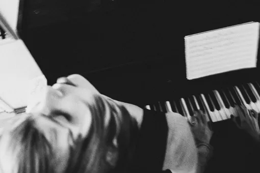 Работник центра играет подопечным на пианино. Ульяне нравится музыка — она ее успокаивает Фото: Лиза Жакова для ТД