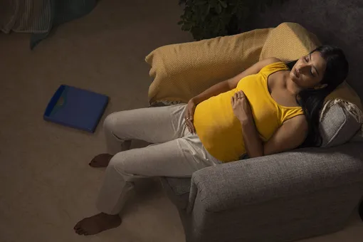 Беременная женщина отдыхает на кресле