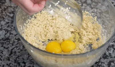 Для приготовления арахисового печенья смешайте в миске сливочное масло, арахисовое масло и сахар. Взбейте туда яйца.