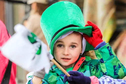 Девочка в шляпе на параде в честь Дня святого Патрика