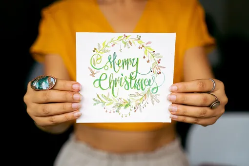 Руки держат открытку Merry Christmas