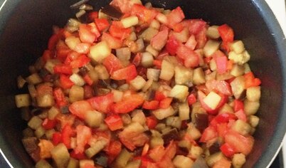 К баклажанам добавить красный перец и помидор.