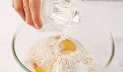 Из муки, яиц, соли и воды замесите тесто. Оно должно быть более клейким, чем для пельменей. Накройте и оставьте на полчаса.
