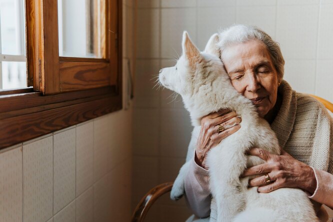 пожилая женщина обнимает щенка