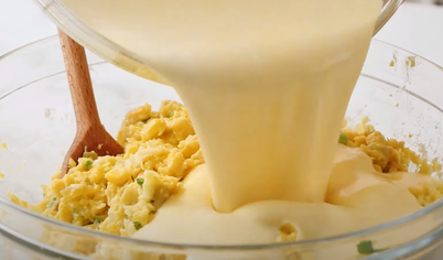 В большой миске взбейте яйца до однородной массы, добавьте туда растопленное масло, сахар и молоко. Далее постепенно вмешайте кукурузный крахмал, добавьте кукурузу и сливки. Тщательно перемешайте смесь. 
