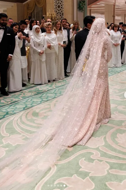 Модельер украсил платье невесты длинным шлейфом